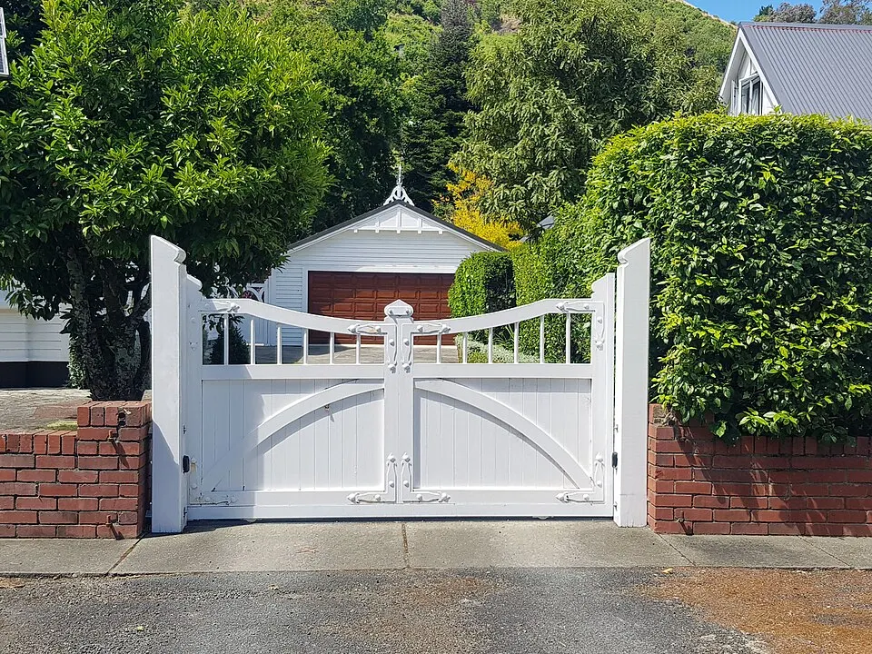 White wooden double driveway gate between brick posts