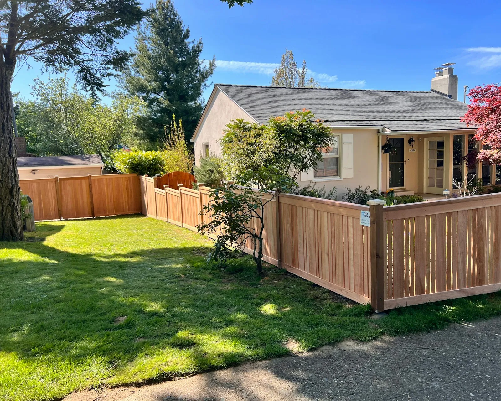 New cedar privacy fence around a ranch house yard
